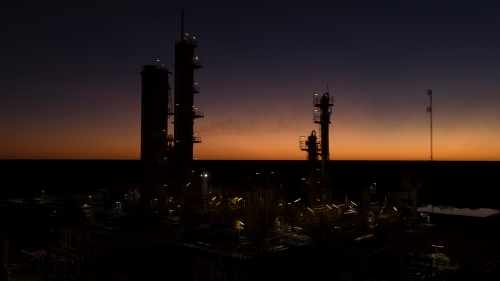 Horizontal shot of an industrial plant approaching sunrise/sunset - Australian Stock Image