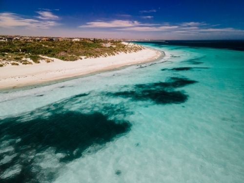 horizontal shot of an island with white sand shoreline, trees and bushes on a sunny day - Australian Stock Image