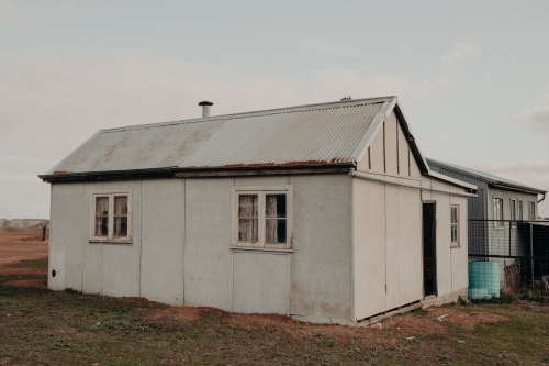 Horizontal shot of an old white farm outbuilding - Australian Stock Image
