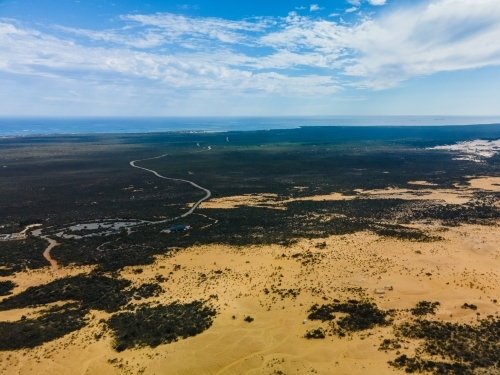 horizontal shot of an outback with green trees and bushes on a sunny day with cloudy skies - Australian Stock Image