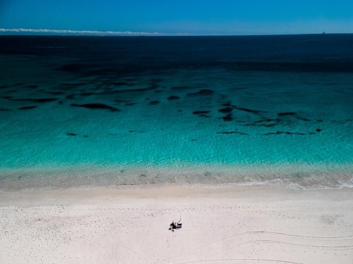 horizontal shot of beach with objects on the white sand on a sunny day - Australian Stock Image