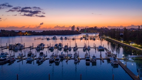 Horizontal shot of boats all lined up at marina at sunset - Australian Stock Image