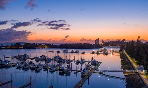 Horizontal shot of boats all lined up at marina at sunset - Australian Stock Image