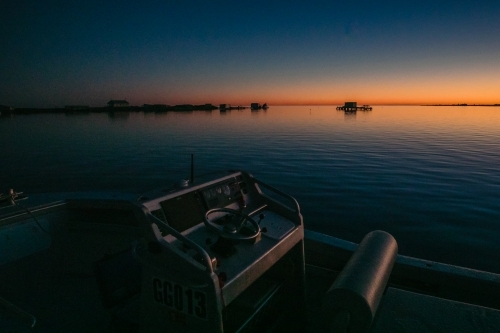 Horizontal shot of boats on the sea at sunset.