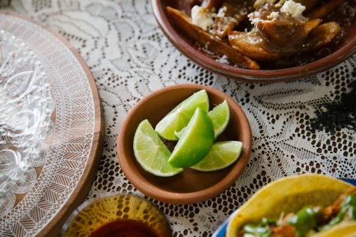 Horizontal shot of fresh lime in a small bowl on a table - Australian Stock Image
