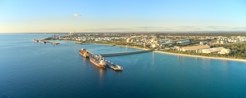 Panoramic shot of Kwinana bulk jetty with large ship docked at the port on a sunny day - Australian Stock Image