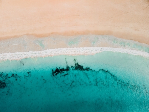 Horizontal shot of ocean waves on empty sand beach - Australian Stock Image