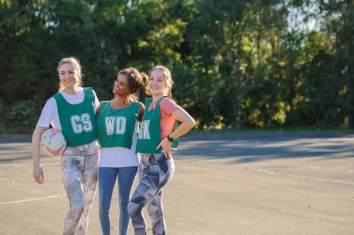 horizontal shot of three young women in sports wear posing outdoors on a sunny day - Australian Stock Image