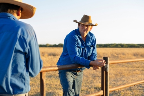 Horizontal shot of two men talking while mustering cattle - Australian Stock Image