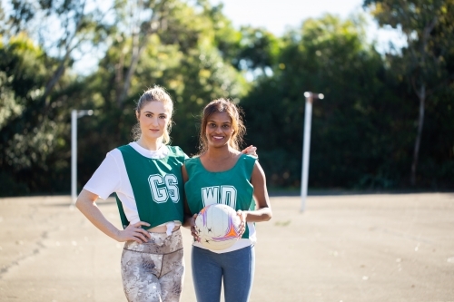 horizontal shot of two young women with one holding a ball - Australian Stock Image