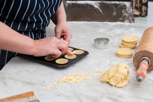 Hospitality worker working pastry into a tray - Australian Stock Image