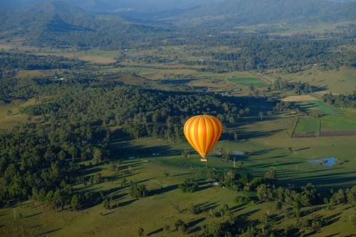 Hot air balloon over the lush green Gold Coast / Scenic Rim hinterland - Australian Stock Image
