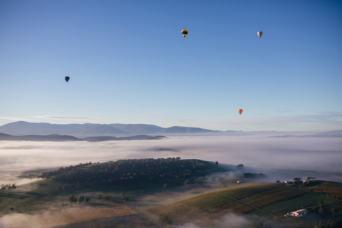 Hot Air Balloons above misty valley - Australian Stock Image