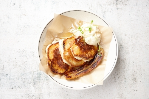 Hot cakes, banana and ice cream dish on table