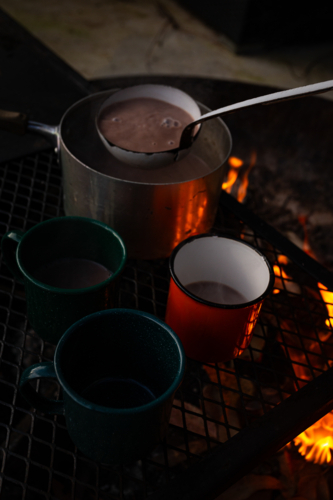 Hot chocolate drink scooped from the pot to the mugs. - Australian Stock Image