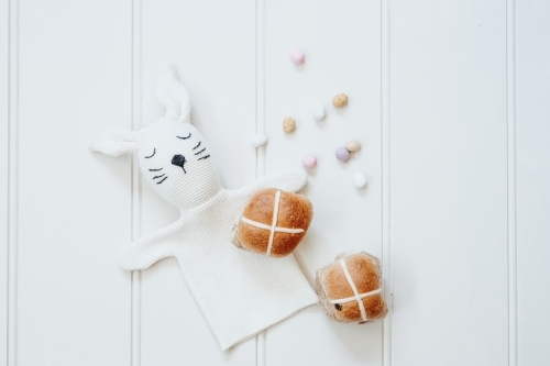Hot cross buns, mini easter eggs and bunny rabbit on white background - Australian Stock Image