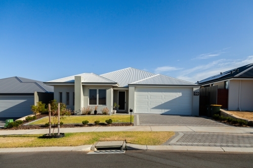 House with neat lawn and driveway to garage - Australian Stock Image