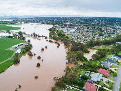 Hunter river in flood overflowing into backyards of homes