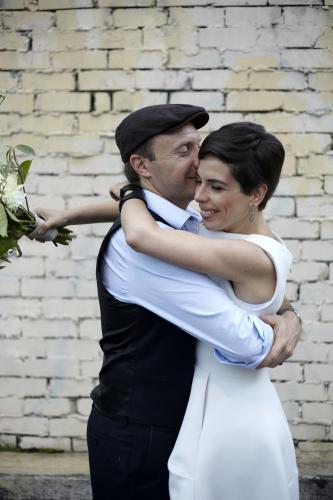 Husband and wife hugging and kissing on wedding day - Australian Stock Image