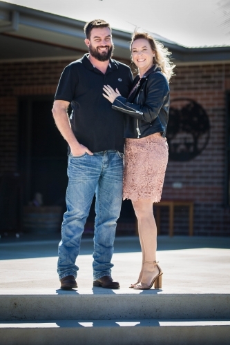 Husband and wife standing on steps at home - Australian Stock Image