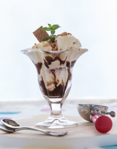 Ice cream sundae with scoop and teaspoons