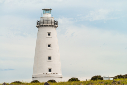 Iconic Cape Willoughby lighthouse viewed against sky with clouds on a day, Kangaroo Island - Australian Stock Image