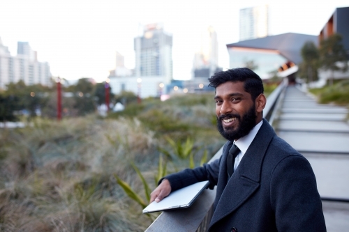 Indian architect with device surveying site - Australian Stock Image