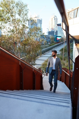 Indian businessman with open collar cheerful outdoors in city - Australian Stock Image