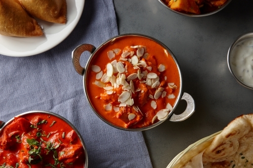 Indian curry dishes on grey table - Australian Stock Image