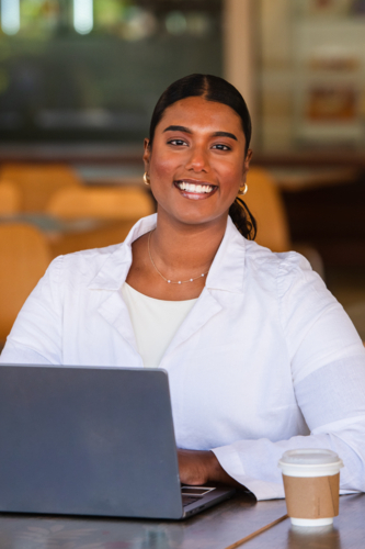 indian woman working on a laptop in a cafe - Australian Stock Image