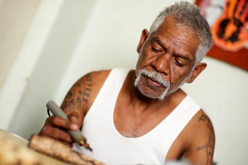 Indigenous Australian Elder making a Message Stick - Australian Stock Image