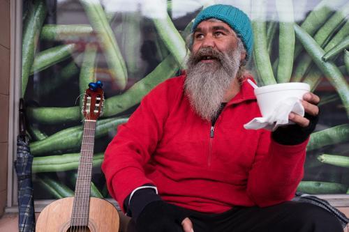 Indigenous Australian Man Having a Break from Busking - Australian Stock Image