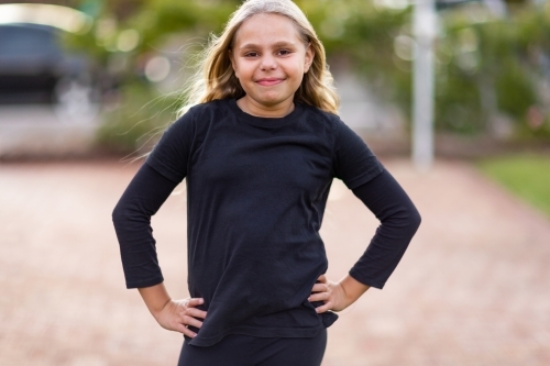 indigenous child in confident stance with hands on hips - Australian Stock Image