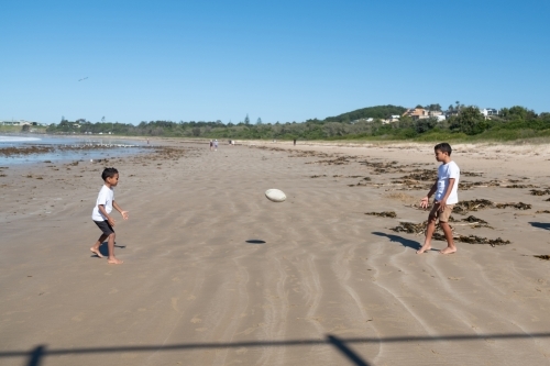 Indigenous children playing ball on the beach