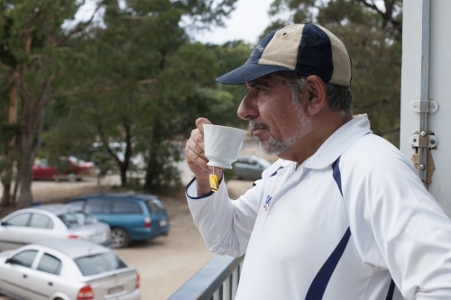 Indigenous cricketer having a cup of tea at the clubrooms - Australian Stock Image