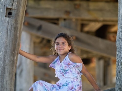 Indigenous girl inside an empty wooden barn - Australian Stock Image