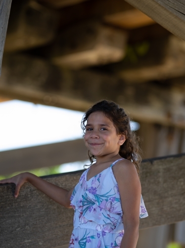 Indigenous girl inside an empty wooden barn - Australian Stock Image