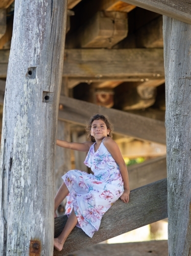 Indigenous girl inside an empty wooden barn - Australian Stock Image