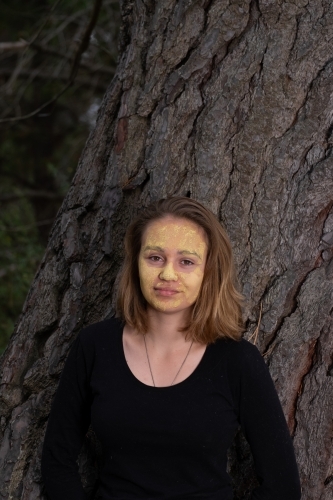Indigenous girl near an old tree - Australian Stock Image