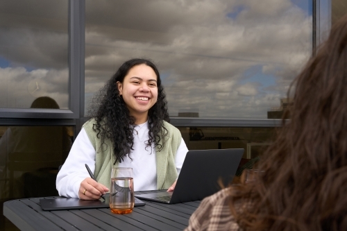 Indigenous woman studying with friend at home - Australian Stock Image