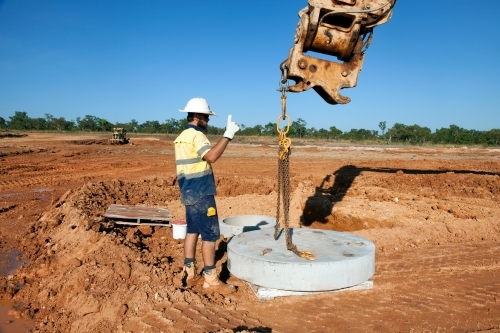 Industrial worker overseeing heavy machinery on a building site - Australian Stock Image