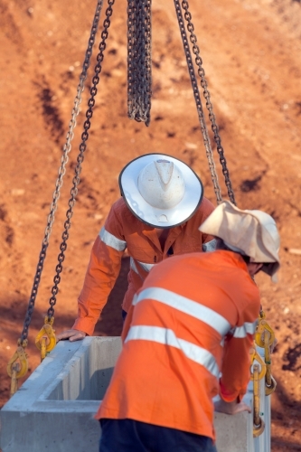 Industrial workers overseeing heavy machinery on a building site - Australian Stock Image