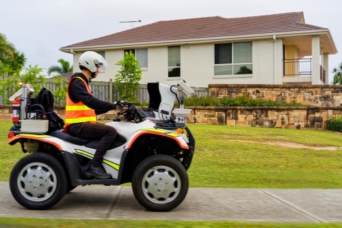 Infrastructure management mobile  man on quad bike testing pavements and walkways in suburban places - Australian Stock Image