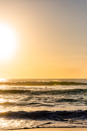 Intense Sun Glare and Reflections on Breaking Waves at Beach - Australian Stock Image