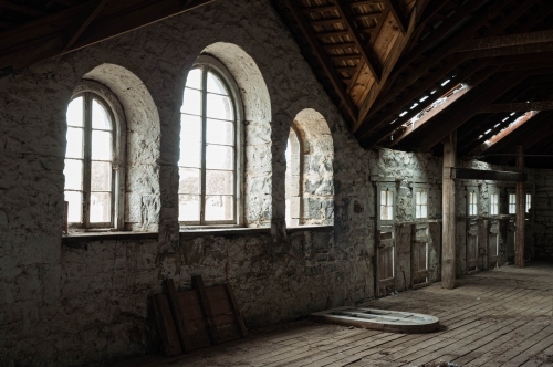interior of abandoned bluestone shearing shed arched windows - Australian Stock Image