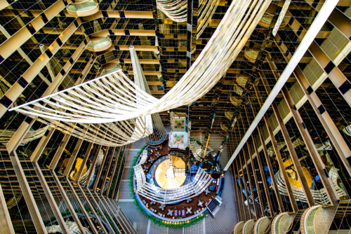Interior view of a grand hotel atrium with modern architecture and hanging fabric installations. - Australian Stock Image