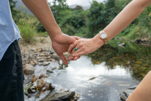Interracial couple holding hands close-up on outdoor walk - Australian Stock Image