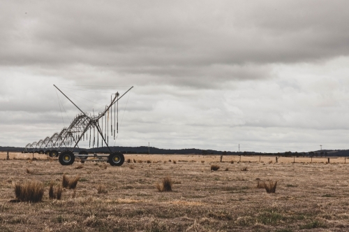 irrigation systems on a rural grassy field - Australian Stock Image