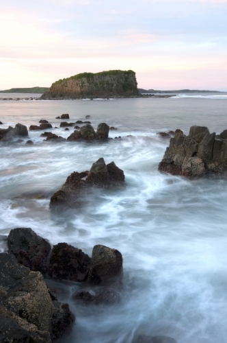 Island and blurred wave motion around rocks - Australian Stock Image