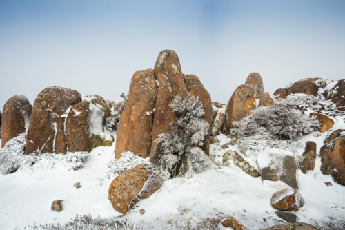 Jagged rock formations covered in rime ice and surrounded by winter snow - Australian Stock Image